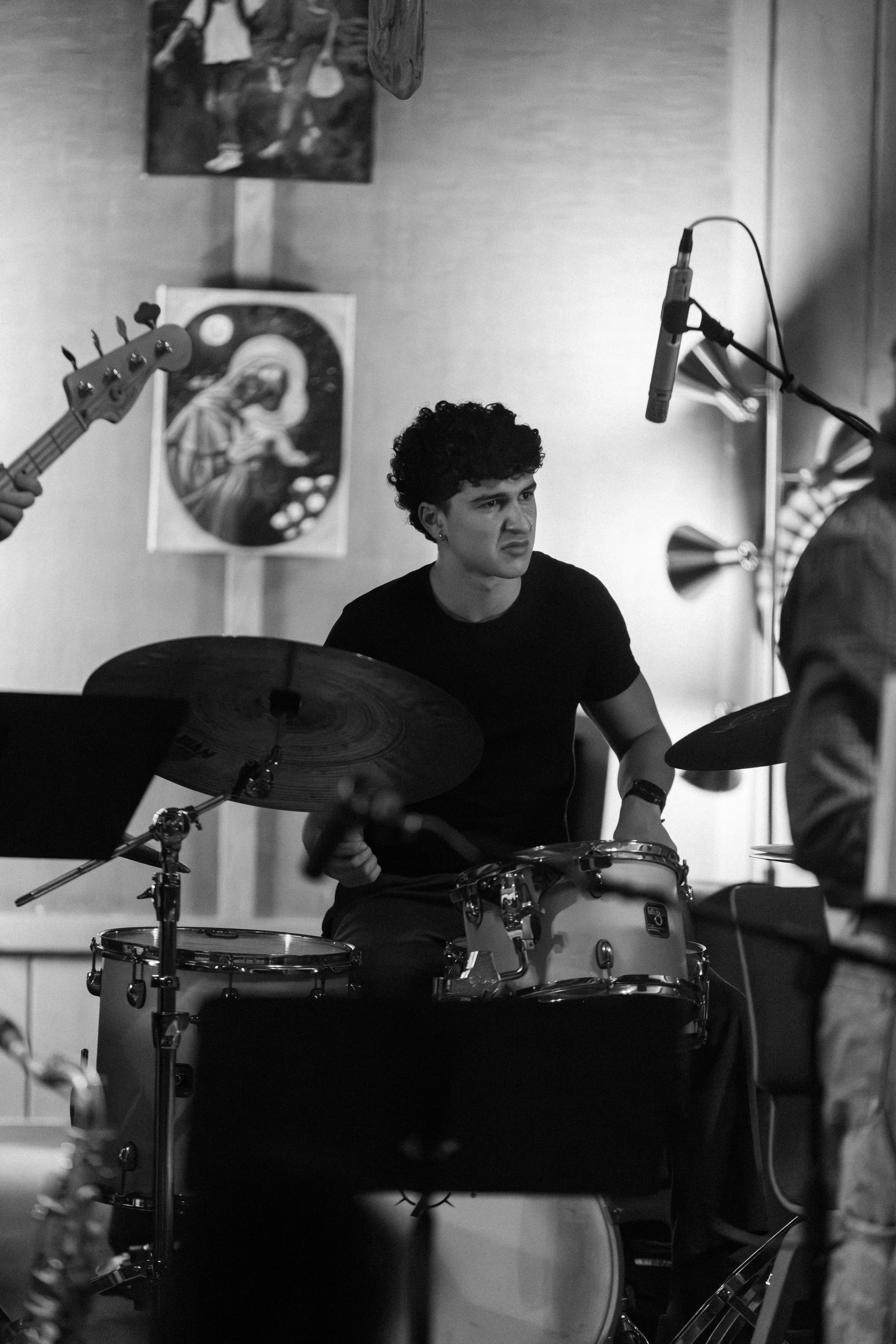 Black and white portrait of Ryan playing drums in a recording session